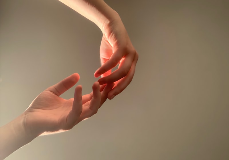 Dos manos que se acercan la una a la otra bajo una luz cálida